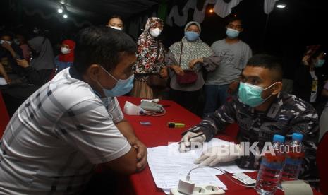 Tim medis dari TNI AL melayani pertanyaan warga saat gebyar vaksinasi di halaman Kantor Gubernur Kalbar di Pontianak, Kalimantan Barat, Ahad (14/11/2021) malam. Dinas Kesehatan Provinsi Kalbar mencatat hingga Sabtu (13/11/2021) sebanyak 1.794.170 orang telah menjalani vaksinasi COVID-19 untuk penyuntikan tahap pertama, 1.052.176 orang untuk penyuntikan tahap kedua dan 21.786 orang untuk tahap ketiga di wilayah Kalimantan Barat.