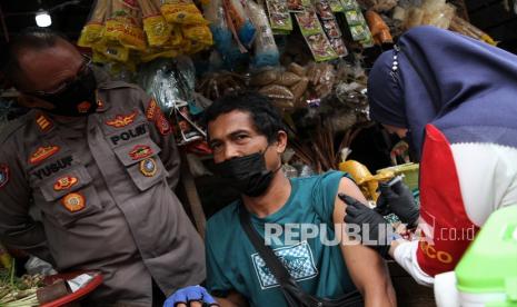 Tim medis Polresta Kendari melakukan vaksinasi COVID-19 dengan mendatangi pedagang di lapak jualannya di Pasar Baruga, Kendari, Sulawesi Tenggara, Selasa (4/1/2022). Survei menemukan 54,8 persen warga tak setuju disuntik vaksin booster.