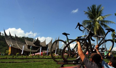   Tim ofisial salah satu pebalap meletakan sepeda balap di atas kendaraan usai memasuki finis etape ke tiga Tour de Singkarak di objek wisata Istano Pagaruyuang, Kabupaten Sumbar, Senin (9/6).  (Antara/Muhammad Arif Pribadi)