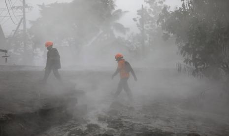  Tim penyelamat berjalan dalam asap dari material vulkanik panas dari letusan Gunung Semeru di desa Kajar Kuning, Lumajang, Jawa Timur, Indonesia, Senin, 5 Desember 2022. Kondisi cuaca yang membaik pada Senin memungkinkan tim penyelamat melanjutkan upaya evakuasi dan mencari kemungkinan korban setelah gunung berapi tertinggi di pulau terpadat di Indonesia itu meletus, dipicu oleh hujan monsun. 