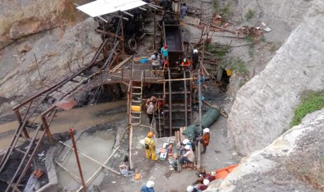  Tim penyelamat dan pekerja menunggu di pintu masuk tambang batu bara saat mencari korban setelah ledakan Jumat, 9 Desember 2022, di Sawahlunto, Sumatera Barat, Indonesia. Sejumlah orang tewas dalam ledakan itu.