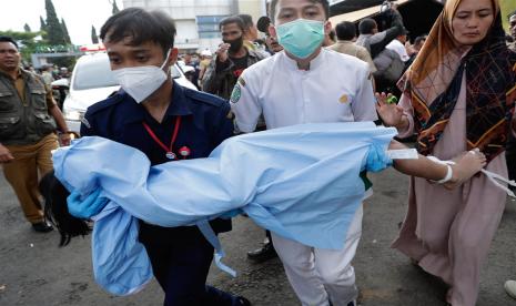  Tim penyelamat dan seorang ibu membawa jenazah seorang anak laki-laki, korban gempa yang melanda Cianjur, Senin, 21 November 2022. Gempa menyebabkan sebanyak 12 siswa SMKN 1 Cugenang di Cianjur, Jawa Barat, terluka.