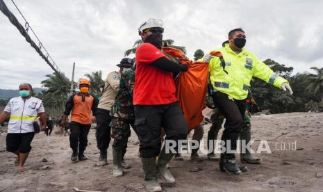 Tim penyelamat membawa jenazah korban di kawasan yang terkena dampak erupsi Gunung Semeru di Lumajang, Jawa Timur,  Senin (6/12.). Gunung meletus pada 04 Desember, menewaskan sedikitnya 14 orang dan menyebabkan puluhan lainnya luka-luka. 