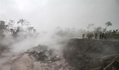  Tim penyelamat memeriksa daerah yang terkena dampak di antara asap material vulkanik dari letusan Gunung Semeru di desa Kajar Kuning, Lumajang, Jawa Timur, Senin, 5 Desember 2022. Pihak berwenang telah menaikkan status siaga Gunung Semeru ke level tertinggi setelah letusannya pada 04 Desember 2022 memaksa sekitar dua ribu penduduk desa meninggalkan rumah mereka. Semeru setinggi 3.376 meter adalah salah satu gunung berapi paling aktif di pulau Jawa. 