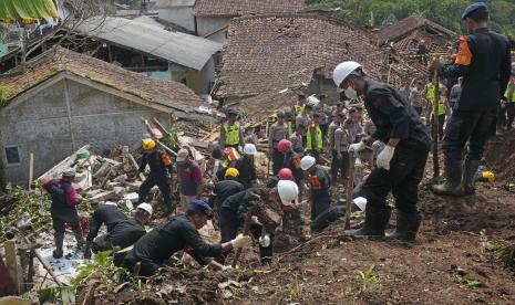 Tim penyelamat mencari korban di sebuah desa yang dilanda tanah longsor akibat gempa di Cianjur, Jawa Barat, Indonesia, Kamis, 24 November 2022. Pada hari keempat pencarian yang semakin mendesak, tim penyelamat Indonesia mempersempit pekerjaan mereka Kamis ke tanah longsor di mana puluhan diyakini terperangkap setelah gempa bumi yang menewaskan ratusan orang, banyak dari mereka adalah anak-anak. 