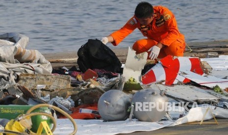 Seorang anggota Basarnas memeriksa puing pesawat Lion Air JT 610 pascakecelakaan,di Pelabuhan Tanjung Priok Jakarta, Senin (29/10/2018).