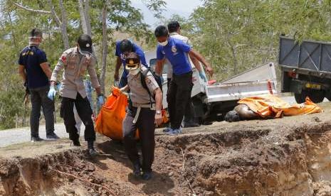 Tim penyelamat mengangkat jenazah korban tsunami untuk dikuburkan secara massal di Palu, Sulteng, Senin (1/10). Penguburan massal membutuhkan perangkat berat untuk menggali lubang besar bagi korban gempa dan tsunami yang terjadi tiga hari lalu.  