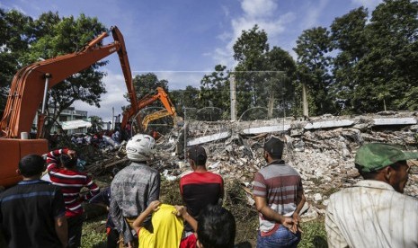  Tim penyelamat  menggunakan excavator untuk mencari korban setelah gempa bumi berkekuatan 6,4 SR yang melanda kabupaten Pidie Jaya, Aceh, (7/12). 