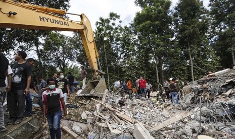  Tim penyelamat  menggunakan excavator untuk mencari korban setelah gempa bumi berkekuatan 6,4 SR yang melanda kabupaten Pidie Jaya, Aceh, Rabu (7/12). 