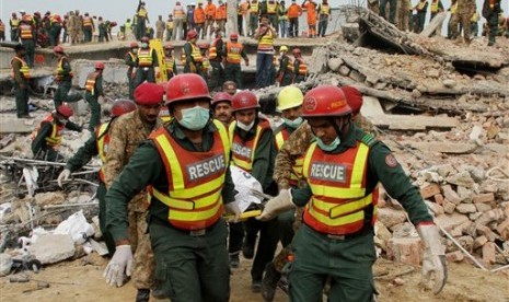 Tim penyelamat Pakistan membawa jenazah korban bangunan runtuh di Lahore, Pakistan, Jumat, 6 November 2015. 