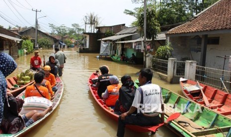 Tim Relawan Rumah Zakat dan BIJB menyusuri perkampungan warga yang terendam banjir untuk menyalurkan bantuan di   Kabupaten Bandung.