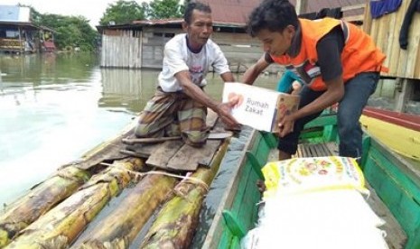 Tim Relawan Rumah Zakat Makassar melakukan penyaluran kepada korban banjir di Kecamatan Tanasitolo, Sulawesi Selatan, Senin (2/7). 