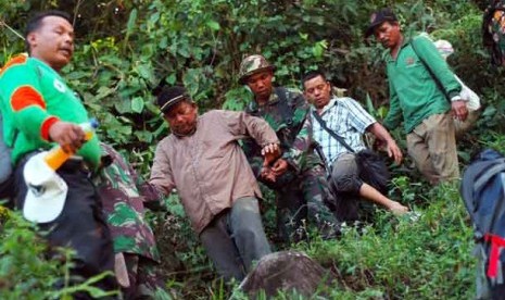  Tim SAR bersama TNI menuntun Ketua DPRD Kabupaten Solok, Syafri Datuak Siri Marajo (dua kiri) menuruni bukit, saat evakuasi 21 peserta napak tilas di hutan Patamuan, Pauh, Padang, Sumbar, Jumat (31/5).