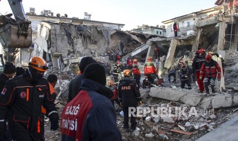 Tim SAR berusaha menyelamatkan korban yang terjebak di reruntuhan gedung yang hancur akibat gempa di Elazig, Turki bagian timur, Ahad (26/1). Korban  jiwa gempa bumi yang melanda Provinsi Elazig, Turki bertambah menjadi 38 orang.