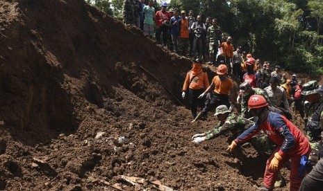 Tim SAR gabungan melakukan pencarian korban yang tertimbun longsor di Desa Banaran, Kecamatan Pulung, Ponorogo, Jawa Timur, Ahad (2/4). 