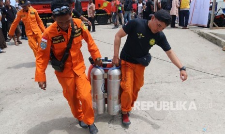 Tim SAR gabungan mengangkat perlengkapan selam saat pencarian korban tenggelamnya KM Sinar Bangun, di Danau Toba, Simalungun, Sumatera Utara, Ahad (24/6).