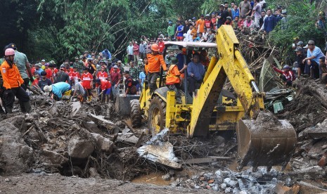 Tim SAR menggunakan alat berat untuk menyingkirkan timbunan tanah, batu dan kayu guna mencari korban terseret banjir bandang di Sambungrejo, Grabag, Magelang, Jateng, Minggu (30/4).