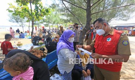 Tim Satgas COVID-19 bersama personel TNI/Polri memeriksa kartu vaksin pengunjung objek wisata Pantai Balongan Indah di Indramayu, Jawa Barat, Senin (27/12/2021). Pemeriksaan kartu vaksin tersebut guna mendorong masyarakat yang belum divaksin untuk segera melakukan vaksinasi COVID-19 yang disediakan di lokasi tersebut.