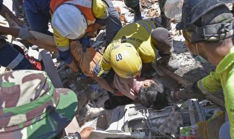 Rescue team members try to evacuate victim found alive in Pemenang Timur Village, Pemenang District, Tanjung, North Lombok, West Nusa Tenggara, Tuesday (Aug 7).