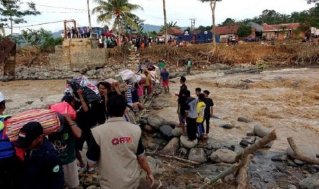 Tim Siaga Bencana (SIGAB) PPPA Daarul Qur’an menerjang banjir untuk mengantarkan bahan-bahan pokok ke Desa Cigudeg, Kabupaten Bogor