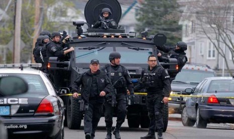   Tim SWAT berada lingkungan di pinggiran kota Boston untuk mencari tersangka yang diduga bersembunyi di sebuah apartemen di Watertown, Jumat (19/4).