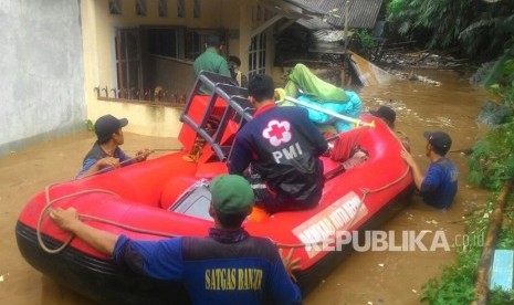 Tim Tagana dan PMi Kota Depok, mengevakuasi sejumlah warga yang rumahnya terendam banjir di bantaran Kali Ciliwung, Depok, Senin (5/1). Banjir disebabkan meluapnya Kali Ciliwung.