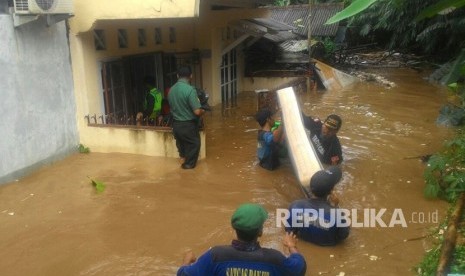 Tim Tagana dan PMi Kota Depok, mengevakuasi sejumlah warga yang rumahnya terendam banjir di bantaran Kali Ciliwung, Depok, Senin (5/1). Banjir disebabkan meluapnya Kali Ciliwung.