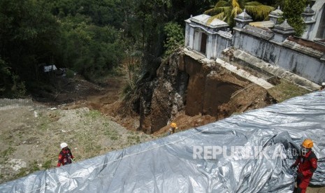 Tim TRC BPBD DIY bersama relawan memasang terpal di area bekas tanah longsor kompleks Makam Raja Mataram, di Imogiri, Bantul, DI Yogyakarta, Jumat (22/3/2019). 