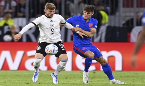 Timo Werner dari Jerman, kiri, berebut bola dengan John Stones dari Inggris selama pertandingan sepak bola UEFA Nations League antara Jerman dan Inggris di Allianz Arena, di Munich, Jerman, Selasa, 7 Juni 2022. 