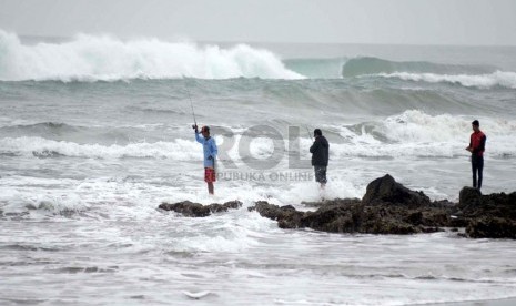   Tingginya gelombang dimanfaatkan oleh para pemancing di Pantai Jayanti, Kecamatan Cidaun, Kabupaten Cianjur, Senin (13/1).  (Republika/Edi Yusuf)