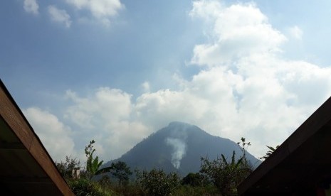 Titik api kebakaran di Gunung Panderman, Kota Batu, mulai berkurang, Selasa (23/7). 