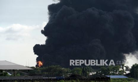 Titik api terlihat di antara asap mengepul dari tanki yang terbakar di area Kilang Pertamina RU IV Cilacap, Jateng, Sabtu (12/6/2021). General Manager Pertamina RU IV Cilacap Joko Pranoto, menyebutkan bahwa saat ini petugas masih berusaha untuk memadamkan titik api di outlet nozel T39-203. 