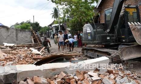 TNI bersama warga terdampak gempa membersihkan puing bangunan rumah akibat gempa di Dusun Lendang Bajur, Desa Gunungsari, Kecamatan Gunungsari, Lombok Barat, Rabu (5/9).