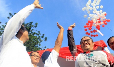 Menteri Pertanian Andi Amran Sulaiman (kedua kanan) dan Gubernur Jabar  Ahmad Heryawan (kanan) melepas balon saat launcing pangan murah Berkualitas melalui Toko Tani Indonesia, di CFD, Dago, Bandung, Ahad (15/5).(foto : Dede Lukman Hakim)