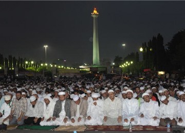  Tokoh Front Pembela Islam (FPI), Habib Rizieq (tiga kanan), bersama massa Forum Umat Islam (FUI) melaksanakan shalat Maghrib di Silang Monas di seberang Istana Merdeka, Jakarta, Jumat (30/3). 