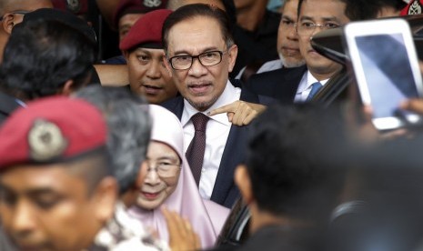 Tokoh reformis Malaysia Anwar Ibrahim dan istrinya Wan Azizah berjalan keluar dari rumah sakit di Kuala Lumpur, Malaysia, Rabu (16/5). Anwar dibebaskan dari penahanannya.