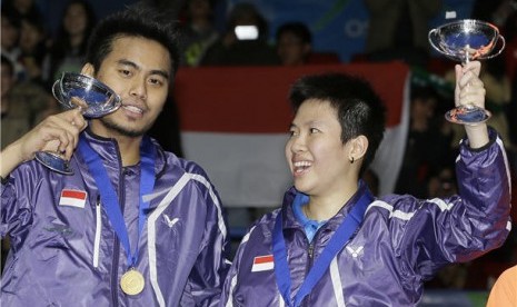 Tontowi Ahmad (kiri) dan Liliyana Natsir memegang trofi usai menjuarai ganda campuran Kejuaraan All England di Birmingham, Inggris.