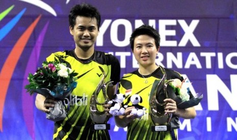 Tontowi Ahmad dan Liliyana Natsir seusai menerima trofi juara Prancis Terbuka, Ahad (26/10).