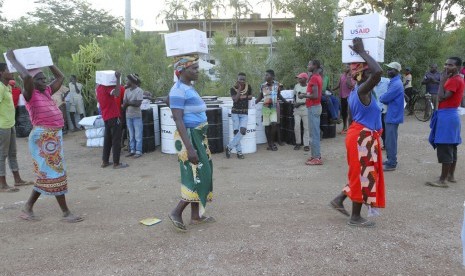 Topan Idai. Wanita mengangkut bantuan makanan di Matarara, 280 km barat dari Beira, Mozambik, (4/4). Ribuan orang kehidupannya berantakan akibat Topan Idai, 