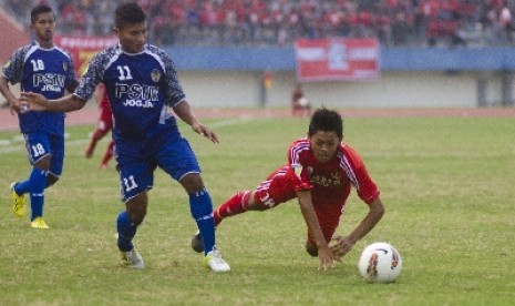 Topas Pamungkas (11) dari PSIM Yogyakarta menjegal pemain Persis Solo Dedi CP (18) dalam pertandingan Divisi Utama Liga Indonesia di Stadion Manahan, Solo, Jateng, Sabtu (27/4)