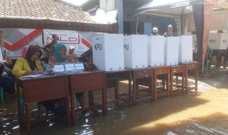 TPS 20 di Kampung Bojong Asih Terendam banjir, meski begitu masyarakat antusias mencoblos, Rabu (17/4).