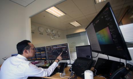 Trader memonitor transaksi pasar keuangan global dari Kantor Cabang Bank Mandiri Singapura di Asia Square Singapura, Kamis (22/9/2022). B