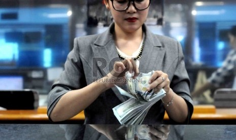  Transaksi penukaran Rupiah terhadap mata uang asing di salah satu tempat penukaran uang, Jakarta, Kamis (23/7).