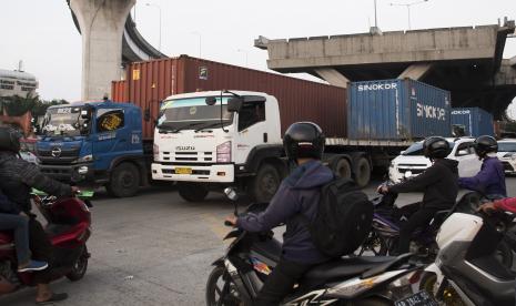 Truk bermuatan peti kemas melintas di kawasan Tanjung Priok, Jakarta Utara, Jumat (11/6/2021). Petugas kepolisian merespon keluhan supir kontainer dihadapan Presiden Joko Widodo saat melakukan kunjungan di Pelabuhan Tanjung Priok dengan mengamankan 49 pelaku pungli yang melakukan aksi di kawasan Tanjung Priok