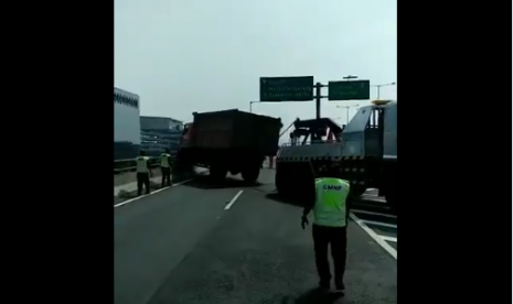 Truk sampah yang menabrak pembatas jalan layang dan hampir terjatuh, sedang dilakukan evakuasi, Senin (11/6).