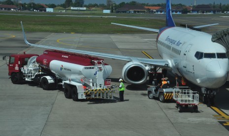 Truk tangki berisi Avtur berada di dekat pesawat yang akan melakukan proses pengisian bahan bakar di bandara. ilustrasi