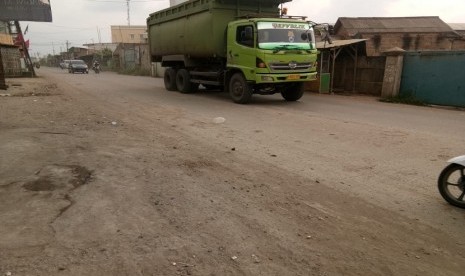 Truk-truk yang membawa tanah ini melewati jalan Marunda Makmur. Tanah yang bertebaran menganggu area sekitar