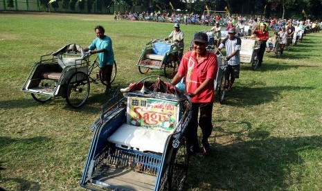 Tukang becak antre pembagian sembako di Jombang, Jawa Timur, Kamis (9/7). 