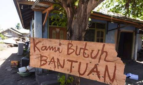 Tulisan pengungsi korban gempa bumi dipasang di sebuah pohon di sekitar lokasi tempat pengungsian darurat di Kayangan, Lombok Utara, NTB, Minggu (12/8).