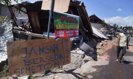 Tulisan pengungsi korban gempa bumi dipasang di sebuah potongan kayu di sekitar lokasi tempat pengungsian darurat di Kayangan, Lombok Utara, NTB, Minggu (12/8). 